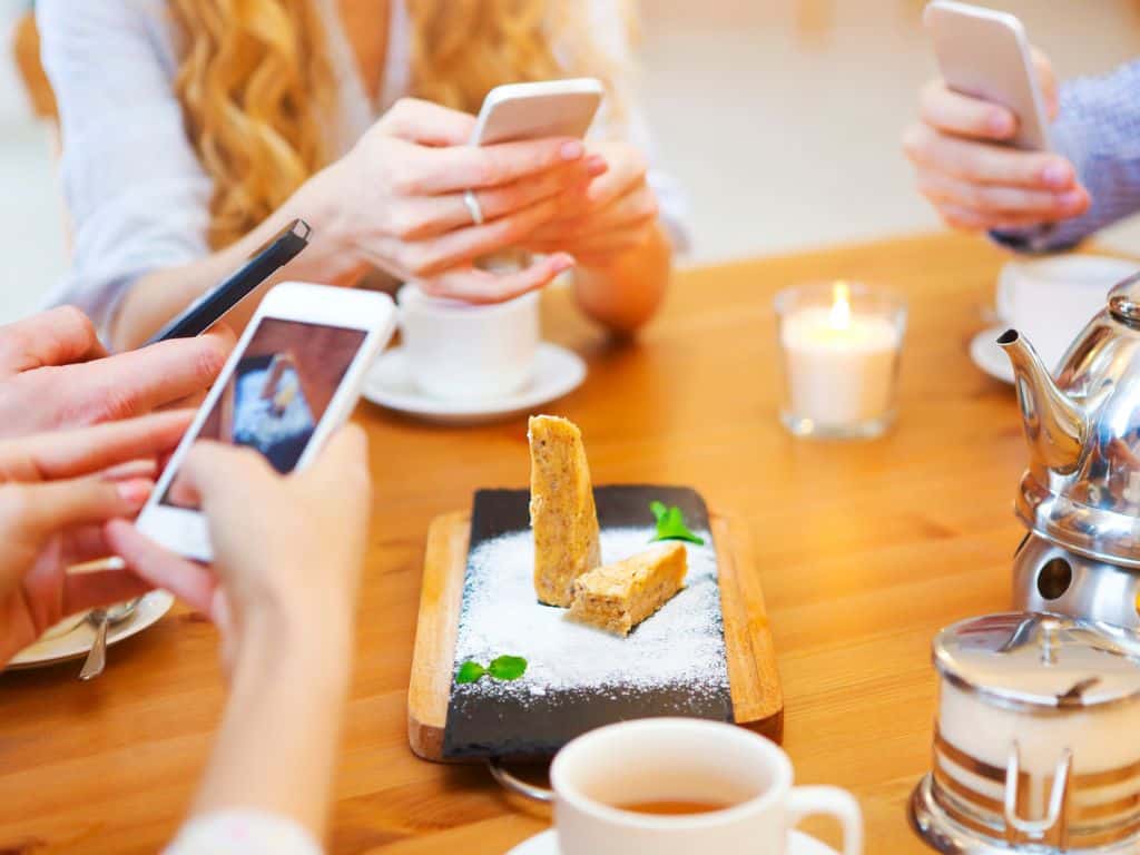 group of friends taking picture of food with their phones
