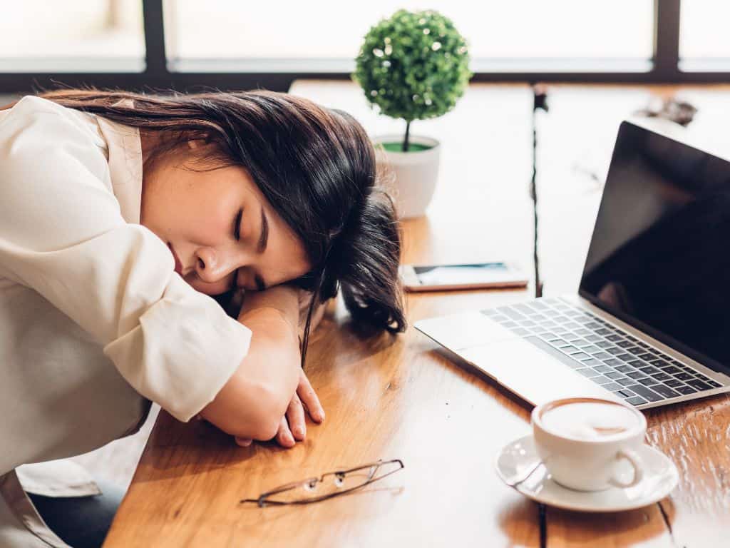 Is freelancing worth it? lady asleep at table with coffee and laptop