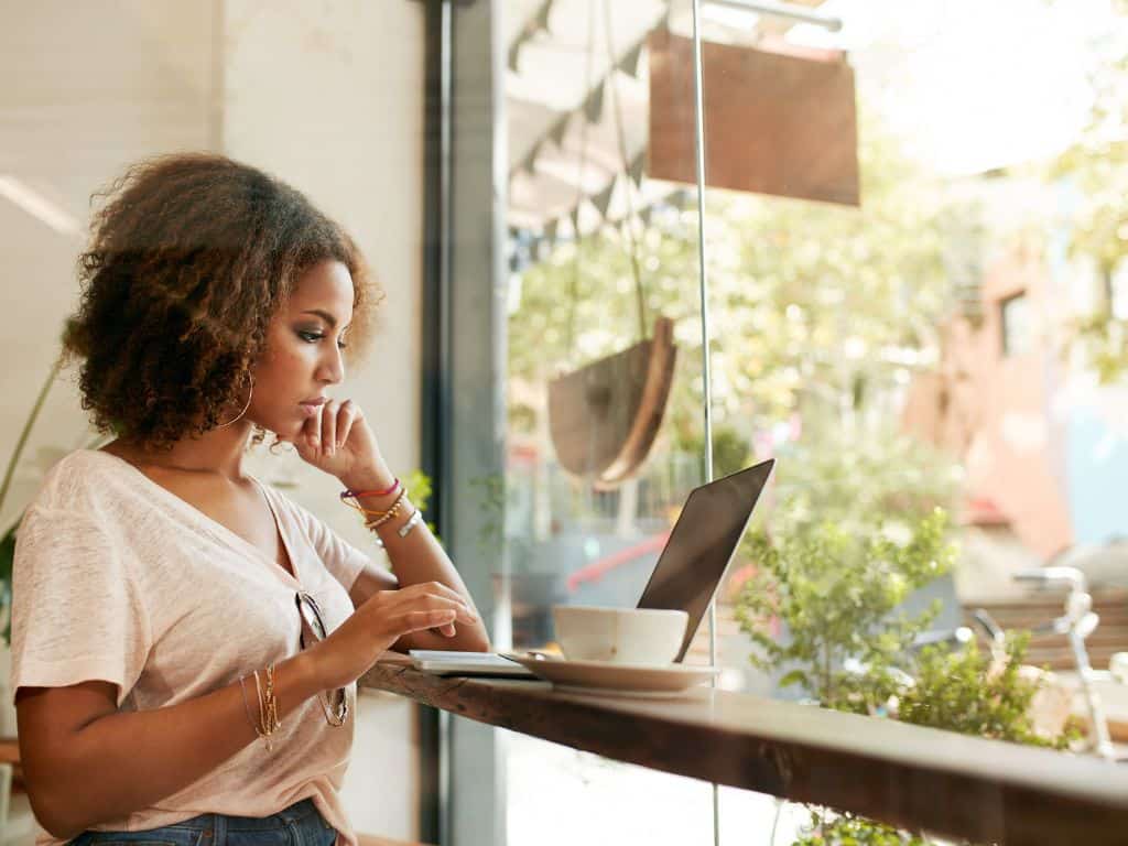 lady working at her laptop with a cup of coffee