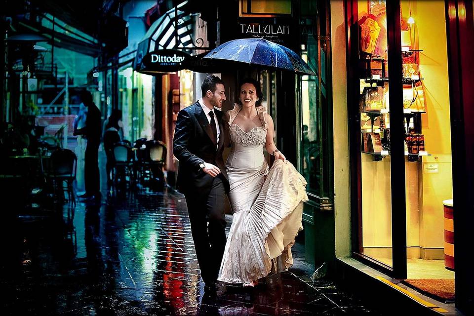 a couple in the rain in wedding gear