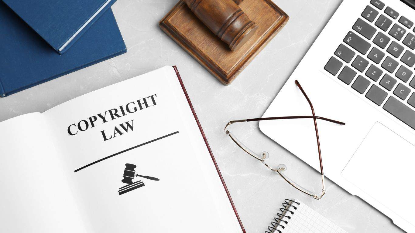 copyright law sample image, with law book, glasses, notebook laptop and law hammer