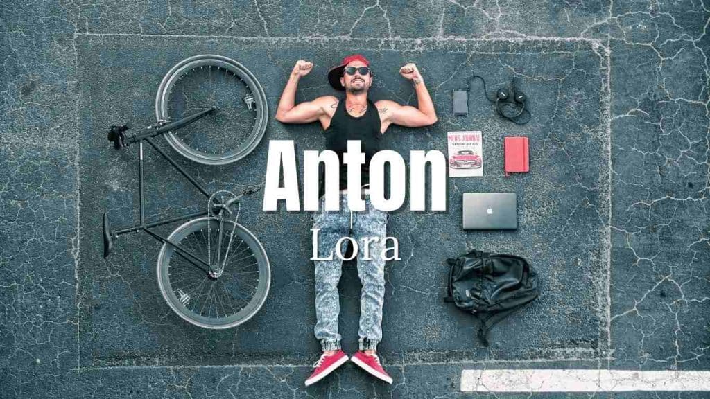 A man with muscles lying on the floor and beside him his bike, bag, laptop, notebook, book, and headset with overlay text Anton & Lora