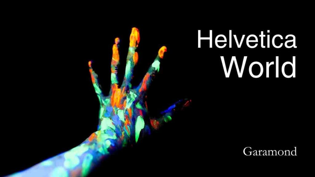 A hand with paint all over and with overlay text Helvetica World & Garamond