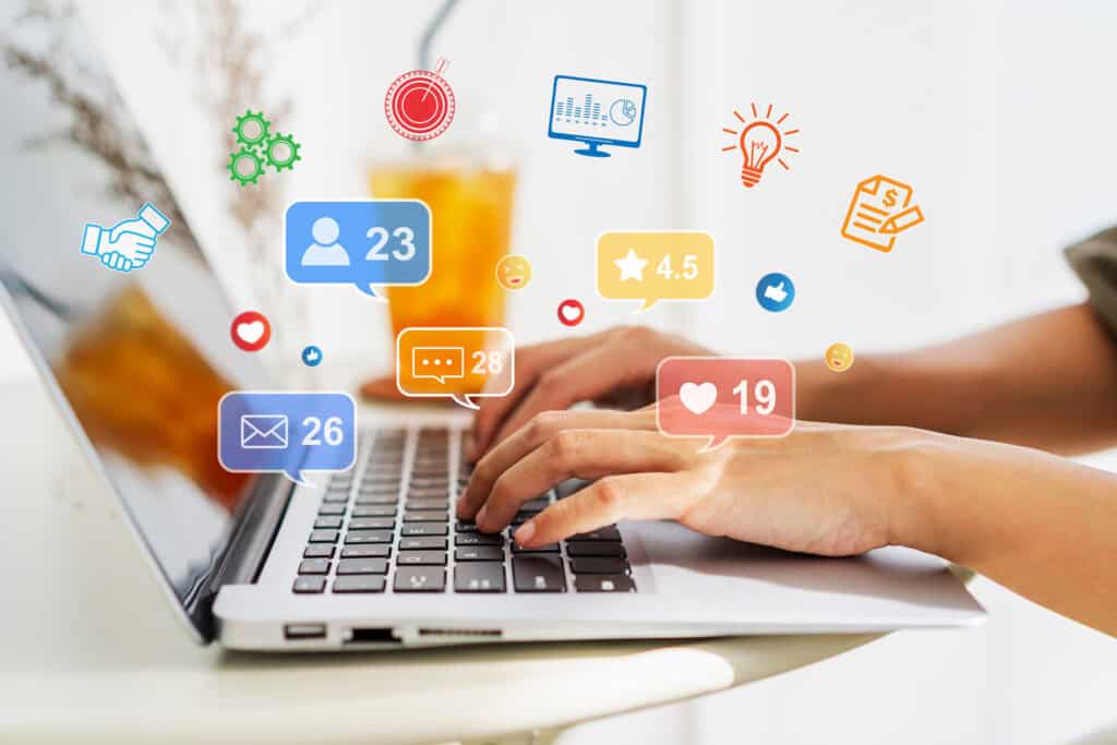 Copywriting Versus Social Media Management: Creative young woman sitting and working on laptop at office, performing social media management