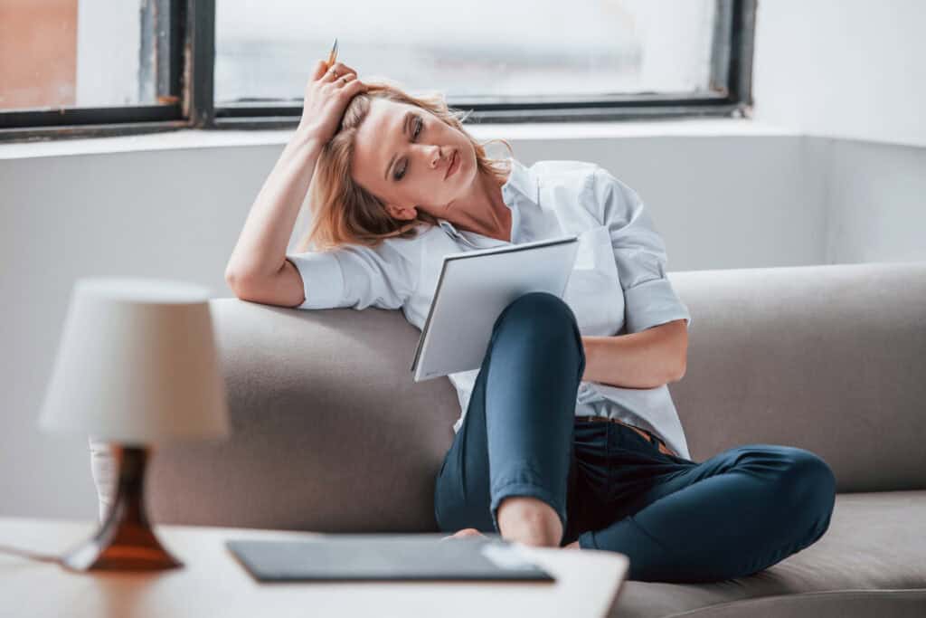 What Freelance Work Can I Do From Home: Woman on couch trying to decide what options she has as a freelancer