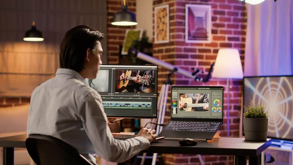 Is Freelancing Free: Man with PC and laptop using multiple editing software for a project