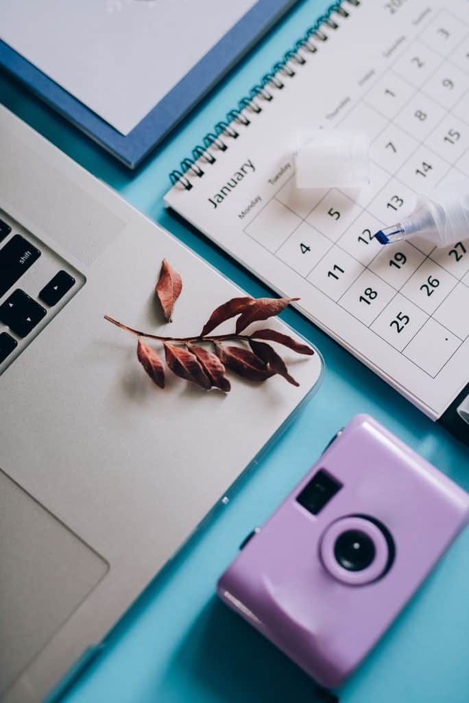 Laptop next to a January calendar on a blue desk, representing a 90-day plan for freelance income streams