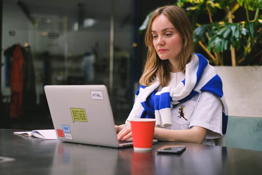 Freelancer working on a laptop in a cafe, representing what skills pay online from anywhere