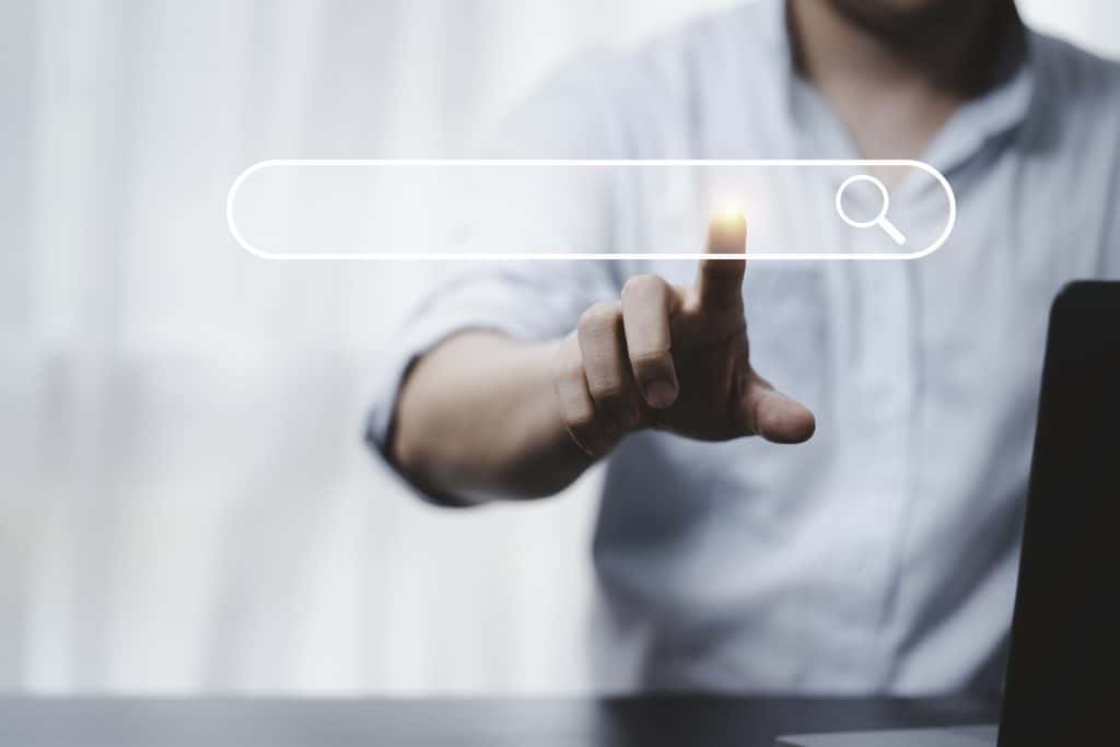 Hand touching a search bar icon, representing generative engine optimization and AI-driven search