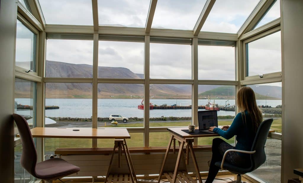 Lady in a blue sweater working against a beautiful lake background