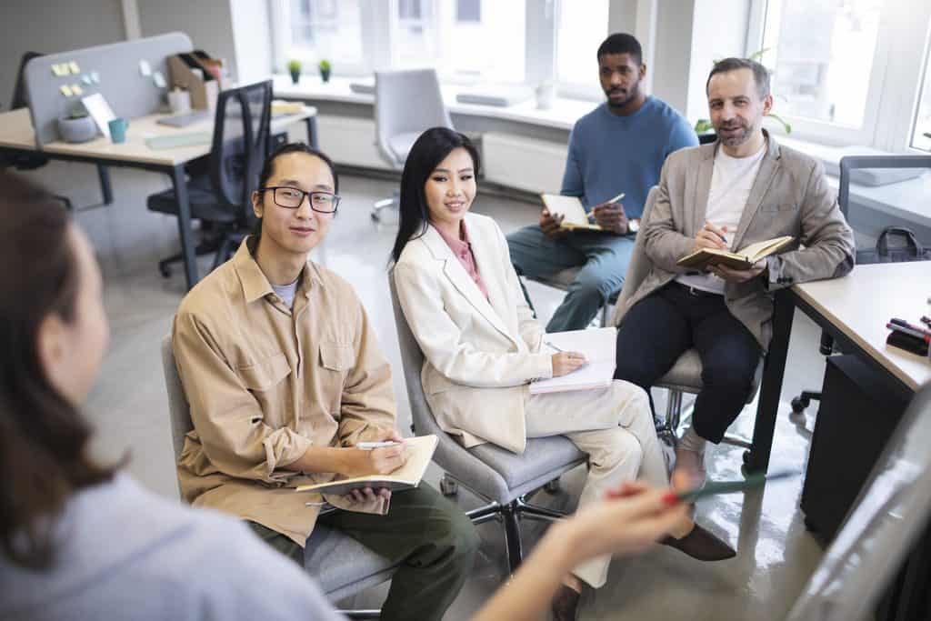 Small group taking notes in a workshop, a feedback-driven copywriting course for freelancers setting