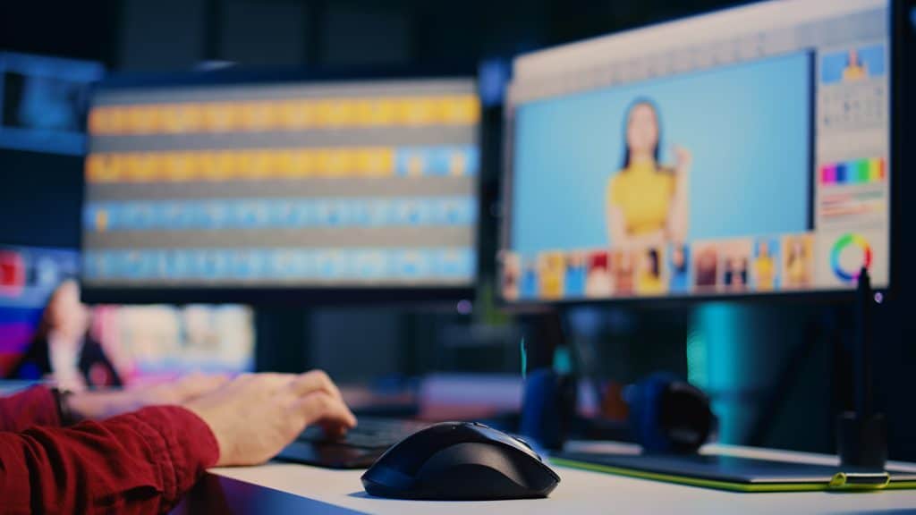 Video editor working on a multi-track timeline and color grading panel across dual monitors, editing a short-form video.