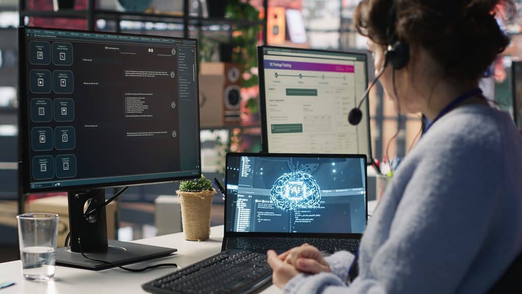 Customer support worker wearing a headset and using an AI chatbot interface across multiple monitors, illustrating the future of freelance careers where AI handles first drafts and humans handle judgment.